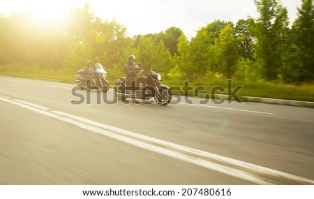 slow motion, two bikers riding unknown motorbike with blur movement, speed concept