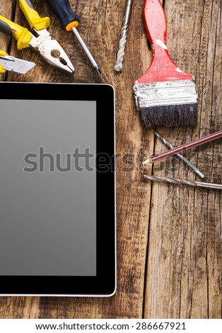 Different equipment tools of builder and tablet pc on wooden texture table