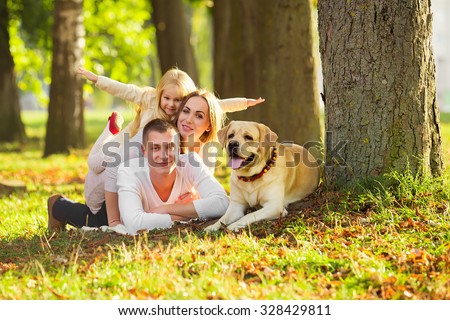 Happy family with their dog in the park on a sunny day