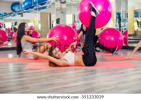Fitness - Young women doing sports training or workout with gymnastic ball in a gym