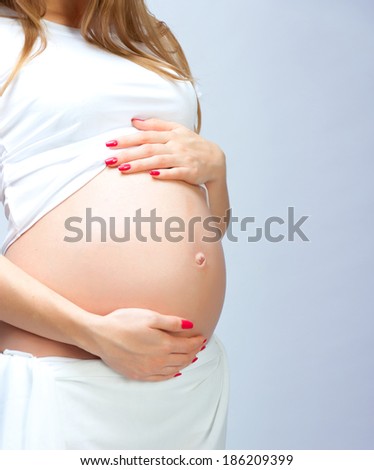 Close-up of pregnant woman with hands over tummy