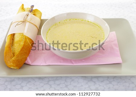 Weddings menu: yellow soup and fresh baguette decorated with lavender.
