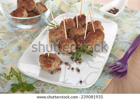 Freshly fried meat balls on a plate.