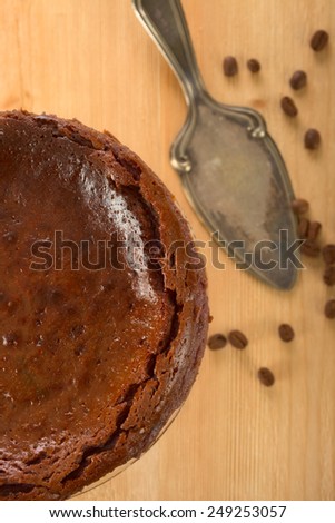 Chocolate cake on a cake platter and coffee bean.