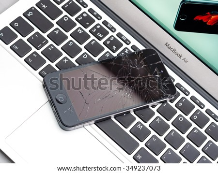Los Angeles, CA, USA - December 07, 2015: Broken Apple iPhone with cracked screen on Apple MacBook Air laptop
