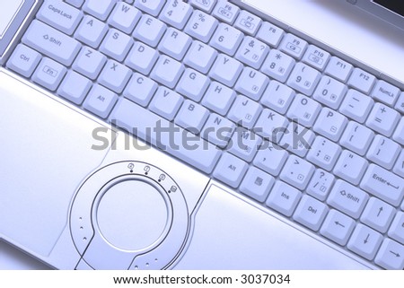 Blue-toned keyboard of hi-end modern laptop with round touchpad