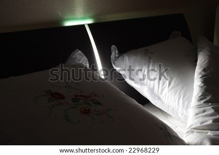 Empty evening double bed in lamp light. Close-up scene.