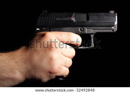 A man tacking aim. Pistol in man hand isolated on black.