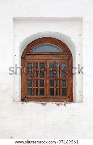 An old arch window and white wall.