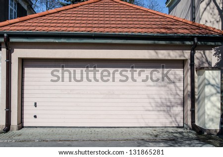 Single family white house with garage gate over blue sky