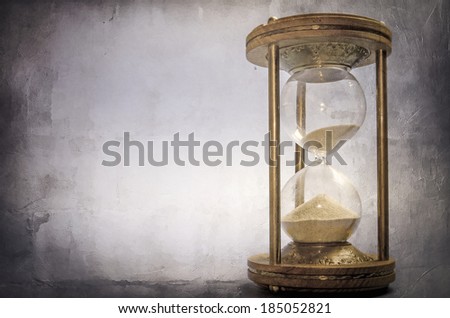 time concept with hourglass lying toned in warm black and white, retro style