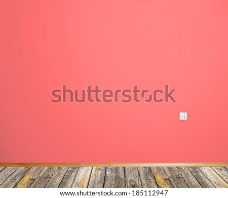 interior room with wooden floor and wall in red with an electrical contact in the wall
