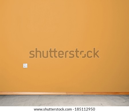 interior room with concrete floor and wall in orange with an electrical contact in the wall