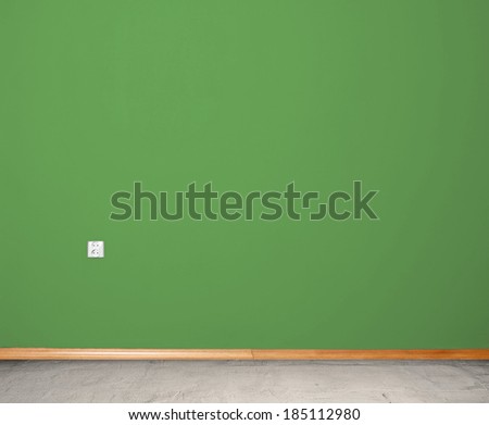 interior room with concrete floor and wall in blue with an electrical contact in the wall