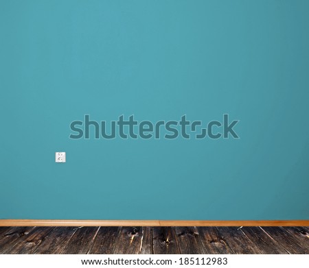 interior room with wooden floor and wall in blue with an electrical contact in the wall