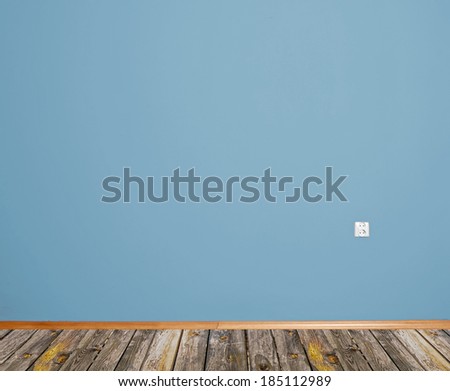 interior room with wooden floor and wall in blue with an electrical contact in the wall