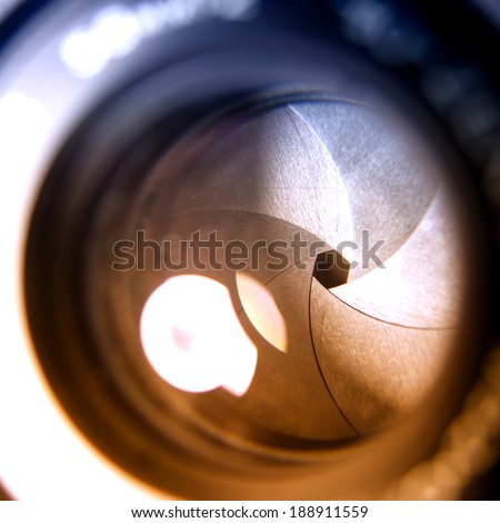 The diaphragm of a camera lens aperture. Selective focus with shallow depth of field. Color toned image.