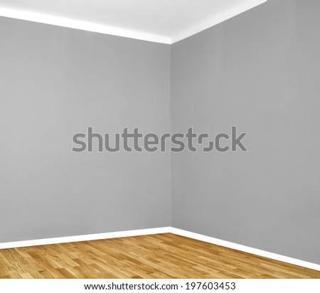 empty room corner with wooden floor and grey wall
