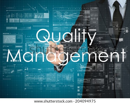 businessman handwriting Quality Management on a transparent board
