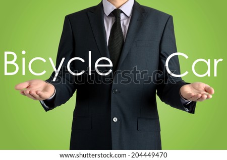 man presents with their hands for a decision problem between bicycle car on green background