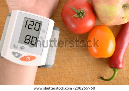 Blood pressure monitor with normal reading concept for illness and heart risk. Pressure gauge with vegetables. The concept shows that healthy food can keep the body in good condition.