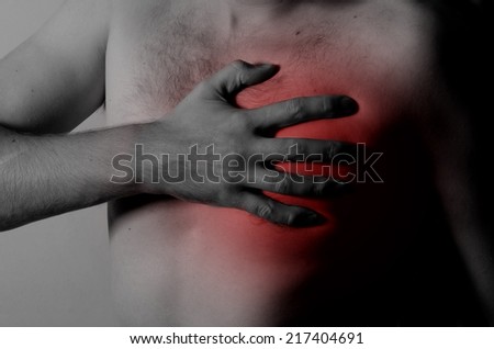 Chest Pain Young man holding hand to spot chest pain