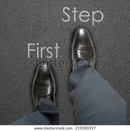 A business man is looking down at his feet and there is a text First step, new business concept