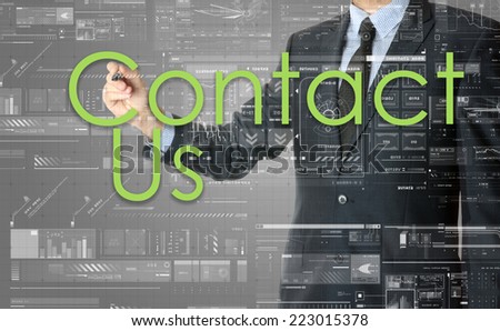 the businessman is writing Contact Us on the transparent board with some diagrams and infocharts with the dark elegant background