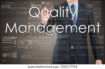 businessman handwriting Quality Management on a transparent board
