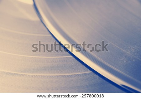 Segment of vinyl record with label showing the texture of the grooves, retro look, music background