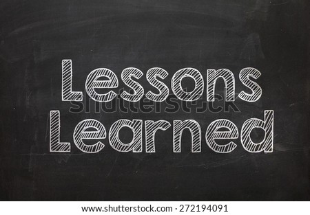 Text Lessons Learned handwritten with white chalk on a blackboard