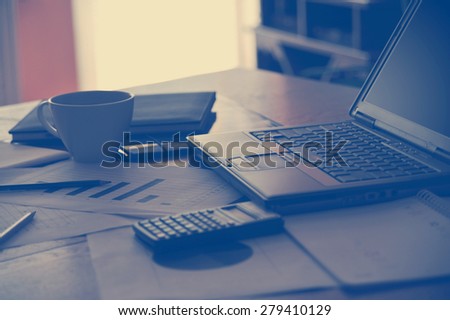 Workplace with open laptop with black screen and business documents with charts growth and pen.- workplace