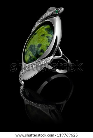 Rings with diamonds and green gem isolated on black background