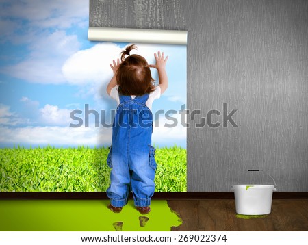 Funny child hanging wallpaper, doing repairs. Eco house concept.