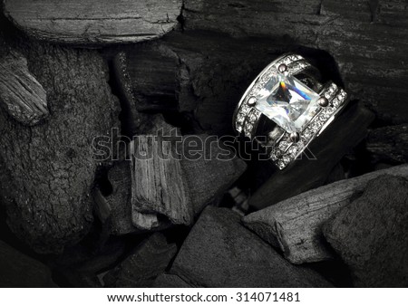 jewelry ring witht big colourful diamond on dark coal background