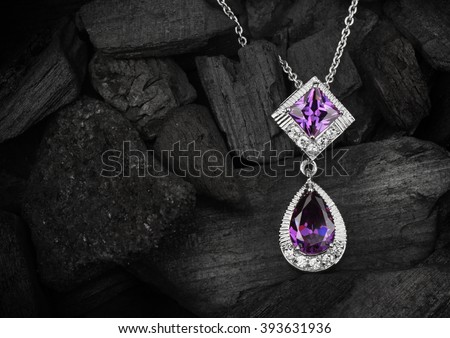 jewelry pendant witht gems on dark coal background