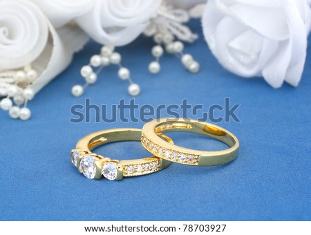 stock photo wedding rings on blue with flowers background