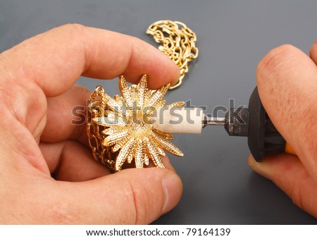 The jeweler is polishing gold
