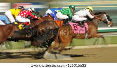 ARCADIA, CA - JAN 17: The field flies down the homestretch in a claiming race at Santa Anita Park on Jan 17, 2013 in Arcadia, CA. Winner is Kevin Krigger (black cap on rail) and \