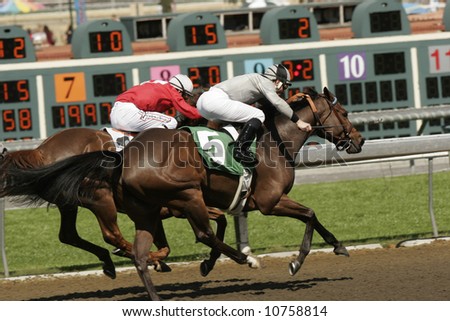 Two jockeys battle for the lead in a thoroughbred horse race.