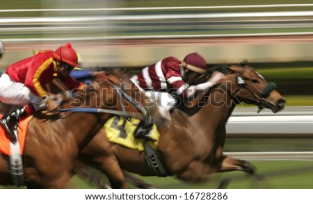 Close-up of Jockeys racing thoroughbreds. Shot at slow shutter speed to enhance motion effect.