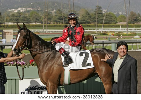 ARCADIA, CA - APR 4: Jockey Victor Espinoza and Acting Lady in the winner\'s circle after winning The Providencia Stakes on April 4, 2009 at Santa Anita Park, Arcadia, California.