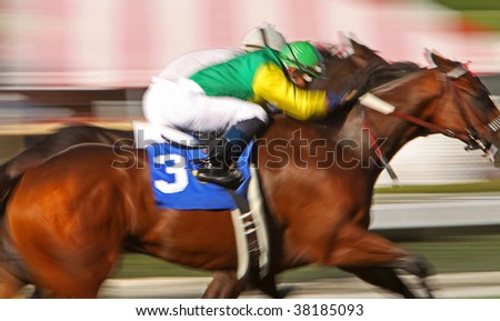 Slow shutter speed rendering of two jockeys struggling for the win in a thoroughbred horse race