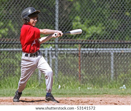 A youth baseball player takes a nice swing at the ball at home plate.