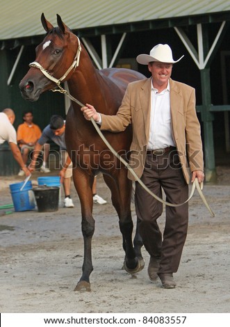 SARATOGA SPRINGS, NY -SEPT 3: Trainer Larry Jones leads Havre de Grace back to her stall after the star filly wins the Woodward Stakes at Saratoga Race Course on Sept 4, 2011 in Saratoga Springs, NY.