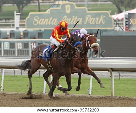 ARCADIA, CA - FEB 19: Jockey Martin Garcia (orange/yellow cap) and Drill run down Martin Pedroza and American Act to win The San Vincente Stakes at Santa Anita Park in Arcadia, CA, on Feb 19, 2012.
