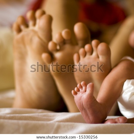 cute newborn foot with family members, focus is tight on the newborn
