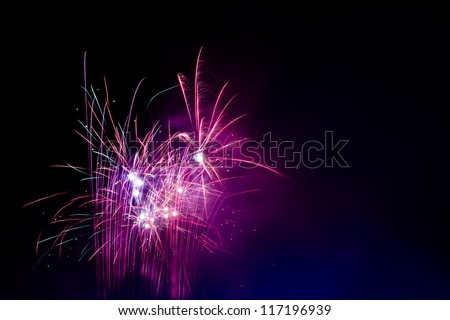 Burst of magenta and pink fireworks during festive celebration.