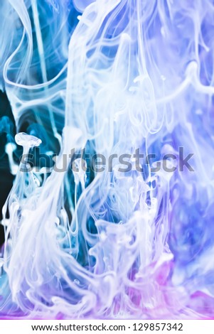 Macro of ink dyes floating through water, abstract, pink,blue and white,