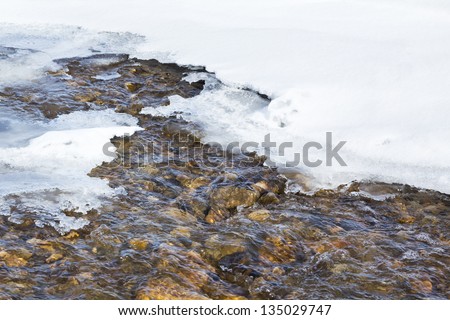 Spring runoff from melting snow raises the water level of streams, rivers and lakes. Landscape format.